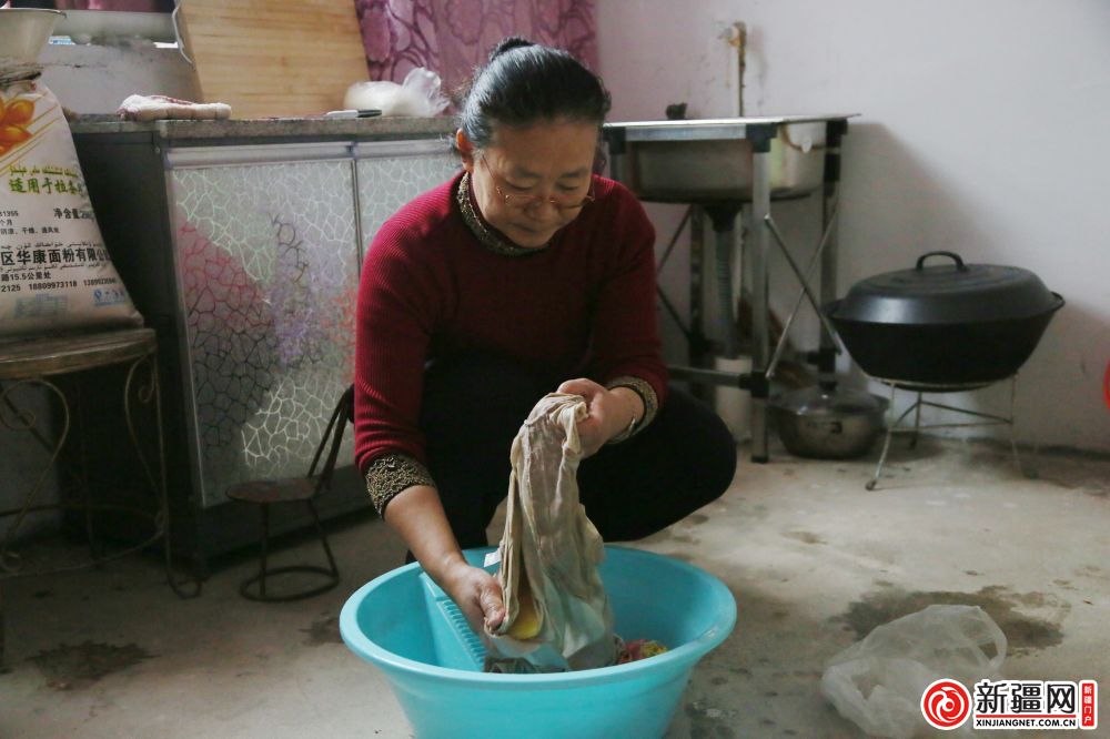 住村干部巴州畜牧兽医局干部张红帮助帕提古丽·阿巴斯婆婆洗衣服