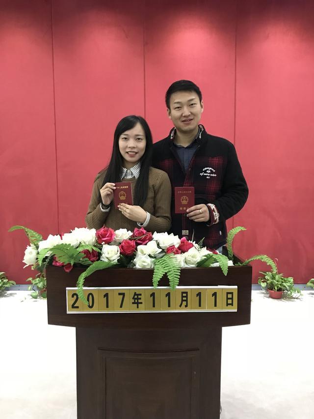 (阮琳摄)洪山区婚姻登记处颁证厅,新人喜滋滋地拍起结婚证书.