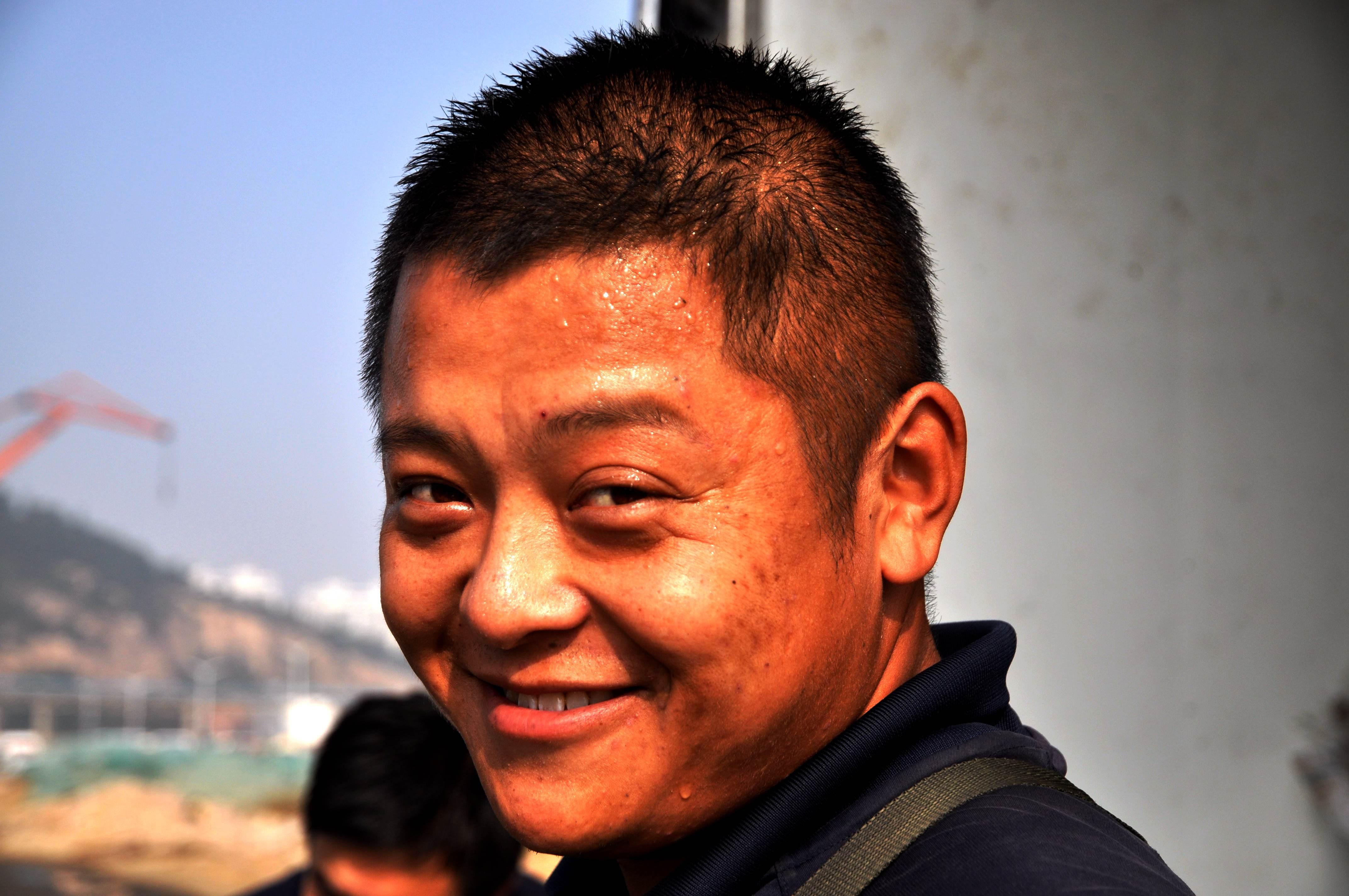 深秋时分,码头上很多市民都裹上了大棉袄,可卸货的渔民小伙,却是满头