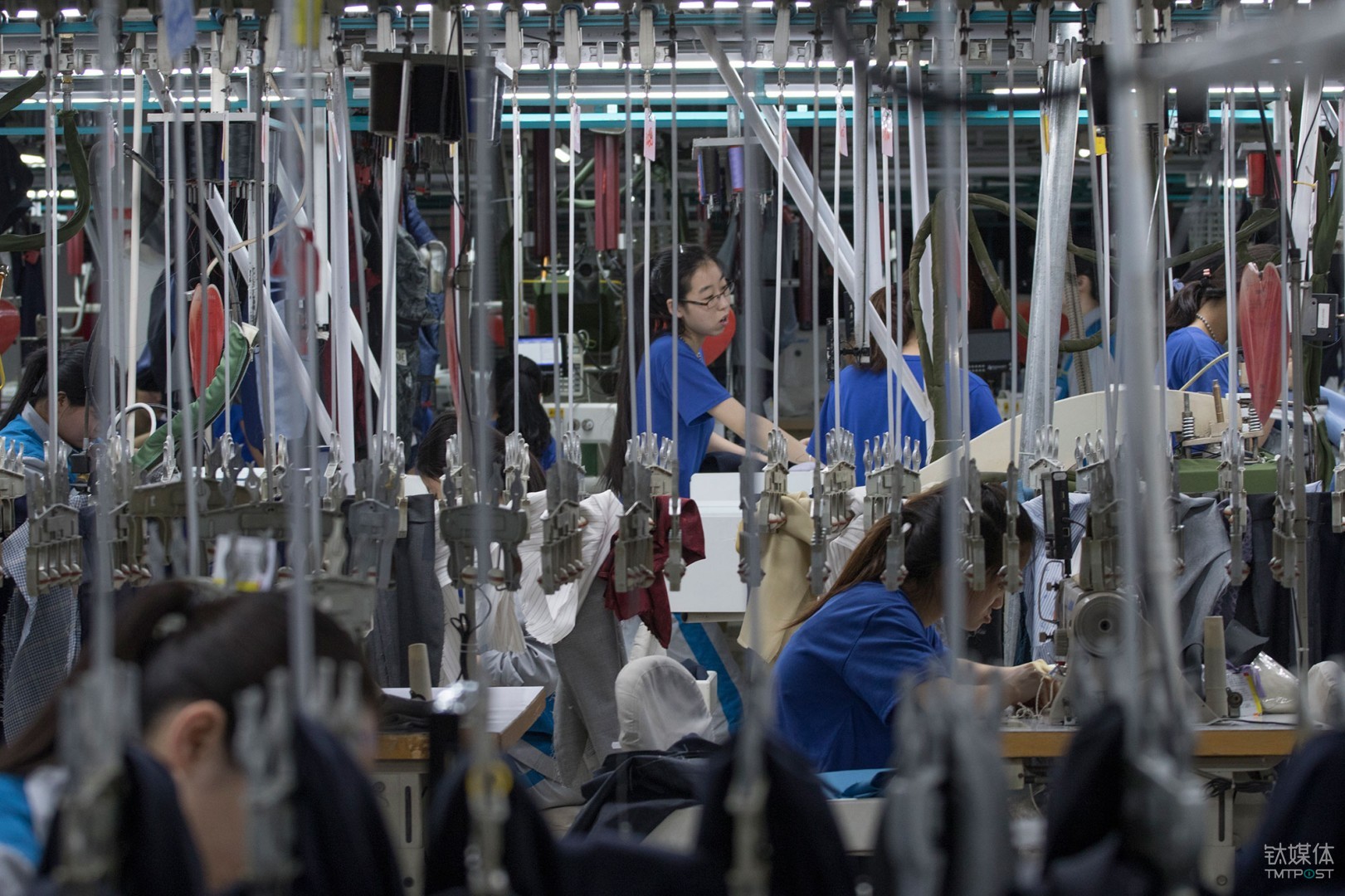 山东青岛,酷特智能车间的西服定制生产线,年轻女工在挂钩间工作.