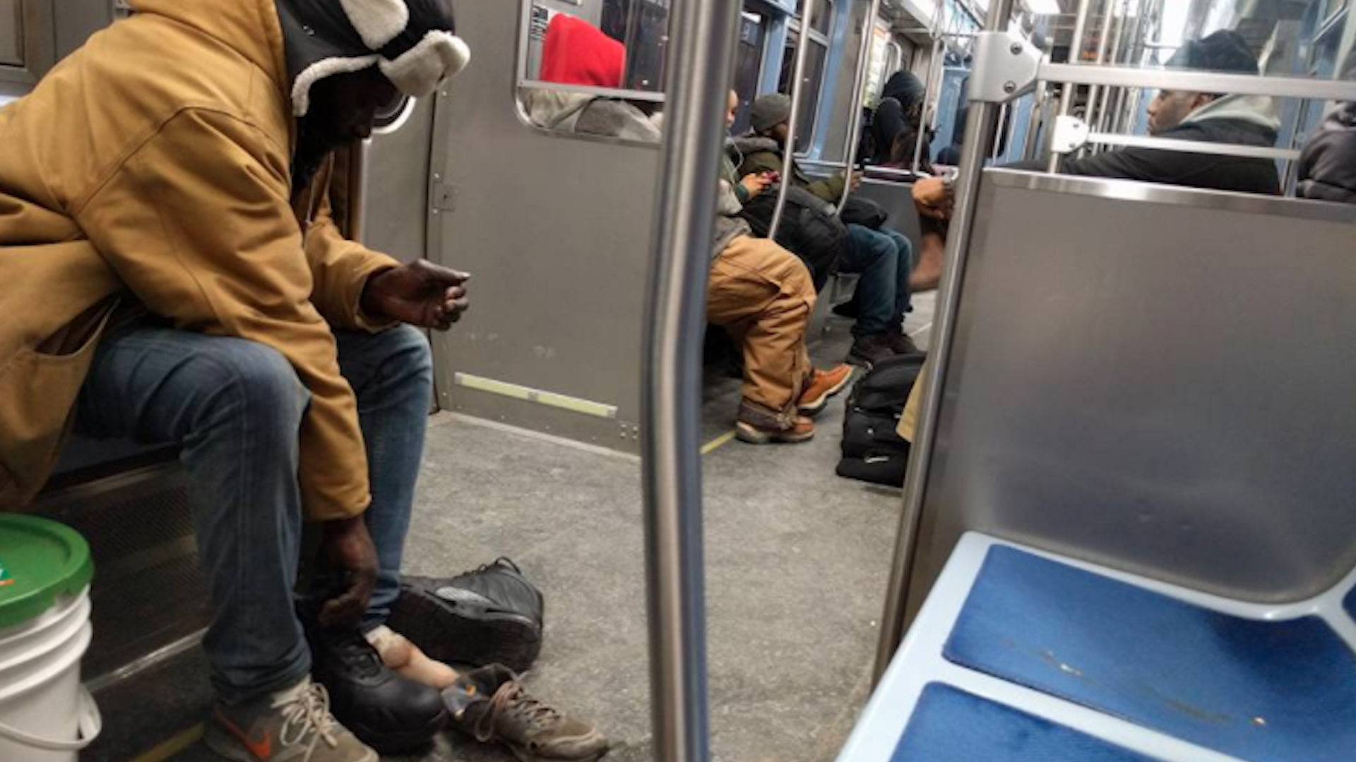 芝加哥地铁上乘客脱下靴子送给流浪者