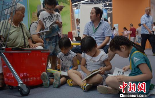 小读者索性一起坐在地上读起新买的书籍 朱志庚 摄