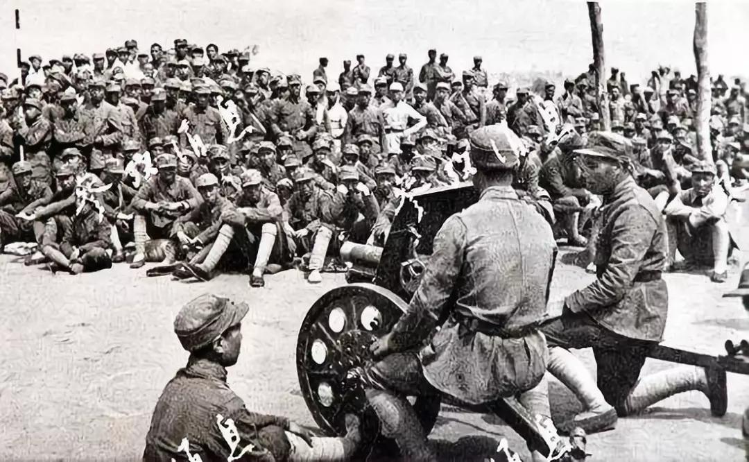 1943年7月,八路军将士们正在围观炮兵们演示一门从北岳东线战斗中
