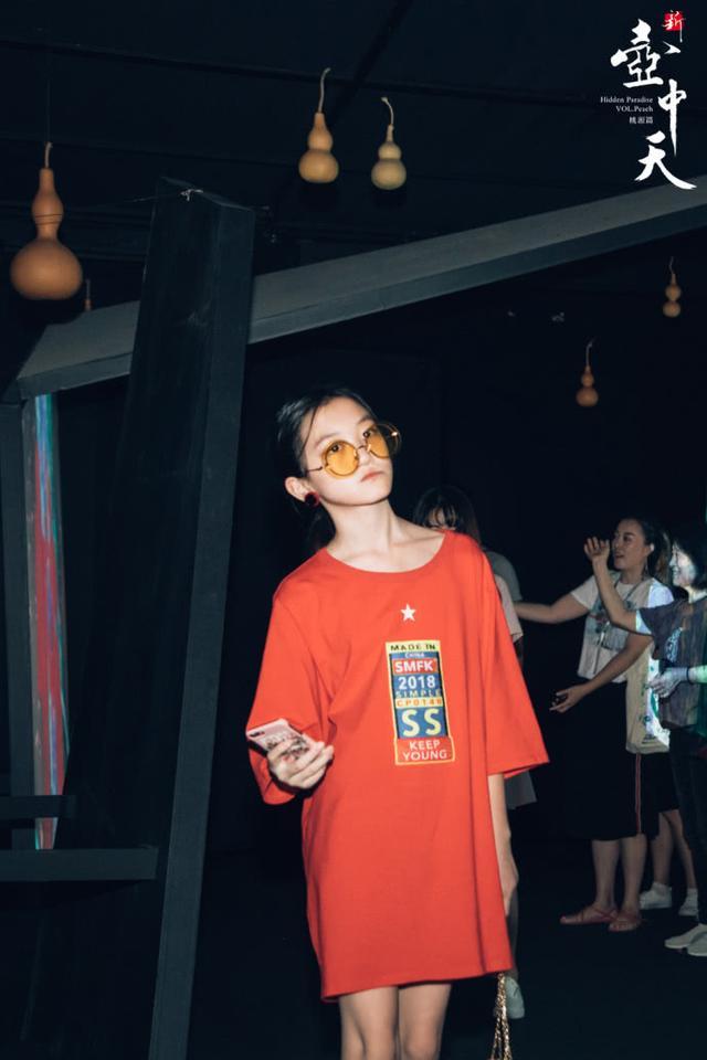 12岁的嫣儿身穿阔大t恤裙,戴着黄色墨镜,十分有范.