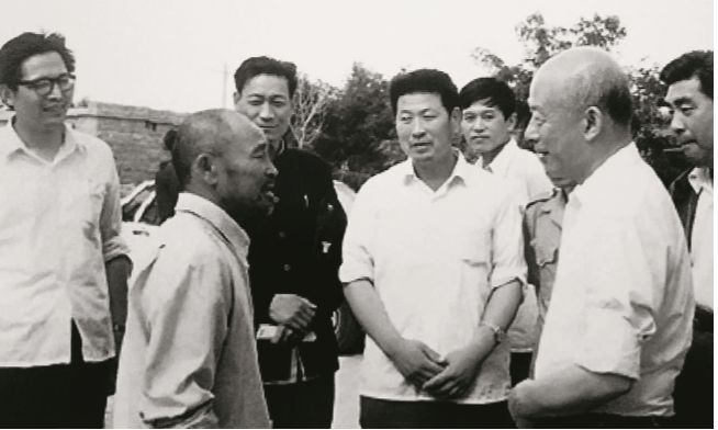 林乎加(前右)在调研期间与当地农民交流.